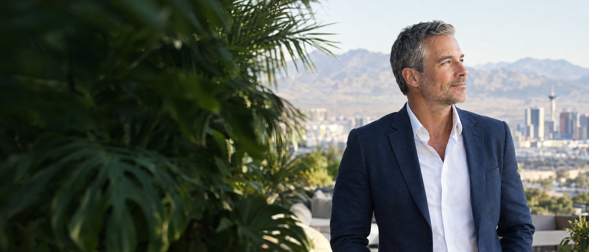 A professional on a leafy terrace overlooking the Las Vegas skyline and mountains