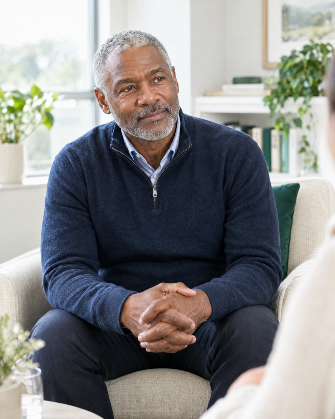 A man in his sixties sits comfortably during a care consultation